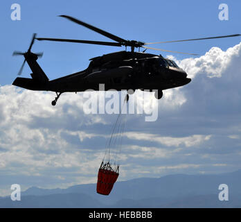 A UH-60 Black Hawk helicopter assigned to Joint Task Force-Bravo's 1-228th Aviation Regiment carries a Bambi Bucket, Jan. 29, 2014. The Bambi Bucket is a specialized aerial firefighting device that allows the aircrew to drop water from above in order to extinguish a fire.  Capt. Zach Anderson) Stock Photo