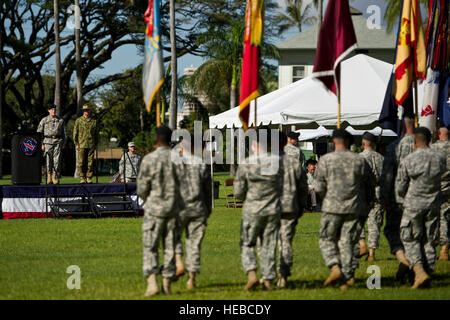 Maj. Gen. Roger F. Mathews, deputy commanding general U.S. Army, Pacific (USARPAC) and Australian Defense Force Maj. Gen. Richard M. Burr, Headquarters U.S. Army Pacific deputy commanding general of operations look on as soldiers assigned to USARPAC, parade the US and Australian Flags during a Jan. 17, 2013, Deputy Commanding General flying V Ceremony at the Historic Palm Circle on Fort Shafter, Honolulu, Hawaii. The ceremony held to welcome Burr and his family as the first foreign military officer to be assigned at this level of leadership in the U.S. Army. Burr's appointment as the USARPAC d Stock Photo