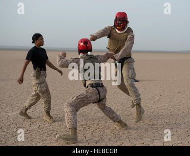 U.S. Marine Corps Sgt. Lawanda Ruiz, Combined Joint Task Force-Horn of Africa Personnel office administration chief, instructs Sgt. Bryan Mack (right) and Cpl. Steven Myint (middle) during the Marine Corps Martial Arts Program instructor's course final field exercise June 26, 2016, at Camp Lemonnier, Djibouti. Ruiz graduated seven students from the course. (U.S. Air Force photo by Staff Sgt. Leslie Keopka) Stock Photo