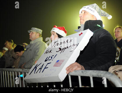 A U.S. Navy member from the NATO Role 3 Multi-National Medical Unit holds a sign during the USO morale event Dec. 16 at Kandahar Air field, Afghanistan. Thousands of NATO service members attended the event which included several high-profile celebrities such as actor Robin Williams, comedians Lewis Black and Kathleen Madigan, musicians Kix Brooks and Bob Dipiero, and athlete Lance Armstrong. U.S. Navy Adm. Mike Mullen, chairman of the Joint Chiefs of Staff, provided opening remarks for the event. Stock Photo