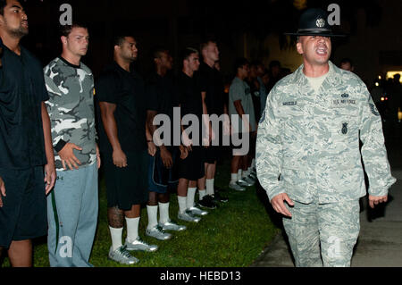 Master Sgt. John Mascolo, 647th Security Forces Squadron and former military training instructor, yells out instructions for the University of Hawaii football players shortly after 5 a.m. during a basic training style wake-up call, Aug. 14, at Joint Base Pearl Harbor-Hickam, Hawaii. Air Force and Navy service members took part in a team building exercise with the team for an early morning physical training session. The Warriors are scheduled to be on the road for their opener Sept. 1, in Los Angeles, against the University of Southern California Trojans. Stock Photo
