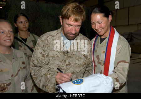 SOUTHWEST Asia -- Capt Carla Stephany-Cox with the 386th Air Expeditionary Wing, gets an autograph signed by Walker, Texas Ranger star, Chuck Norris who is currently visiting troops in Southwest Asia.  Capt. Cox is deployed from Wright-Patterson AFB, OH.  (U.S. Air Force Photo by Staff Sgt. Tia Schroeder) Stock Photo