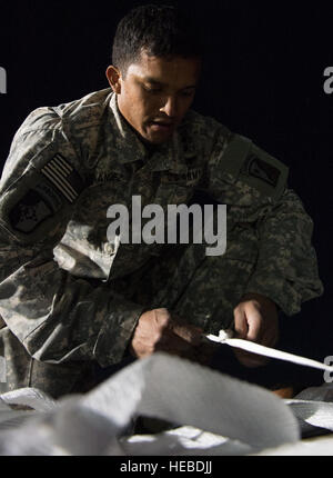 A U.S. Army parachute rigger with the 82nd Airborne Division talks to ...
