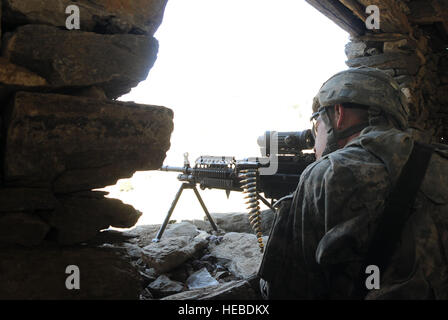 U.S. Army Pfc. Samuel Collins of Clarkston, Va., assigned to Battle Company, 2nd Battalion, 503rd Airborne Infantry Regiment, based at Caserma Ederle, Vicenzia, Italy, maintains a security posture while members of the 204th Civil Affairs team speaks with elders about the completion of a road in the village of Lalam, Afghanistan, Jan. 12. Stock Photo