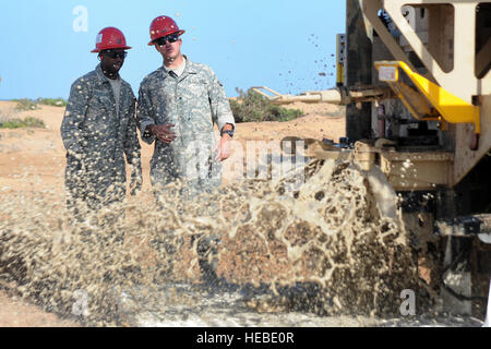 U.S. Army Sgt. Clayburn Johnson (left) and Spc. Michael Knee (right), U.S. Army 257th Engineer Team members, observe the well development process of the second of four newly drilled wells just outside Camp Lemonnier here, March 12. This project allowed the team to evaluate the water tables in the aquifer and make plans for camp expansion. The well development project directly supports Camp Lemonnier's initiative to identify alternative well locations and assist in development of camp infrastructure. (U.S. Air Force photo by Master Sgt. Hector Garcia) Stock Photo