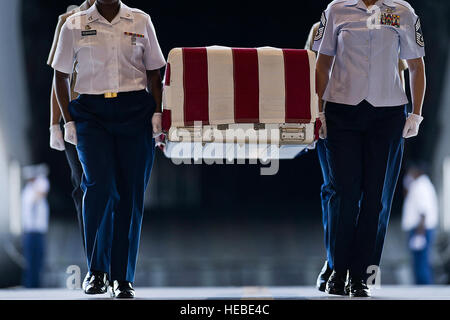 U.S. Army Pfc. Shantilla Robinson (left front), U.S. Air Force Chief Master Sgt. Laura Noel (right front), U.S. Navy Petty Officer 3rd Class India Davis (back left) and U.S. Marine Cassie McDole (back right) escort a flag-draped transfer case from a U.S. Air Force C-17 Globemaster III during the U.S. Joint POW/MIA Accounting Command Arrival Ceremony, Nov. 30, 2012, at Joint Base Pearl Harbor-Hickam. The U.S. personnel whose identities remain unknown are transported to JPAC's Central Identification Laboratory for analyses. The remains receiving full military honors represent losses associated w Stock Photo