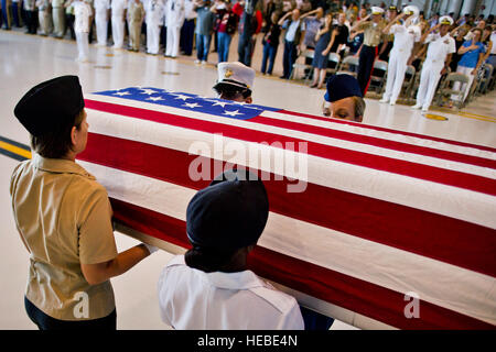 U.S. Army Pfc. Shantilla Robinson, U.S. Air Force Chief Master Sgt. Laura Noel, U.S. Navy Petty Officer 3rd Class India Davis and U.S. Marine Cassie McDole escort a flag-draped transfer case from a U.S. Air Force C-17 Globemaster III during the U.S. Joint POW/MIA Accounting Command Arrival Ceremony, Nov. 30, 2012, at Joint Base Pearl Harbor-Hickam. The U.S. personnel whose identities remain unknown are transported to JPAC's Central Identification Laboratory for analyses. The remains receiving full military honors represent losses associated with World War II and the Vietnam War are from recent Stock Photo