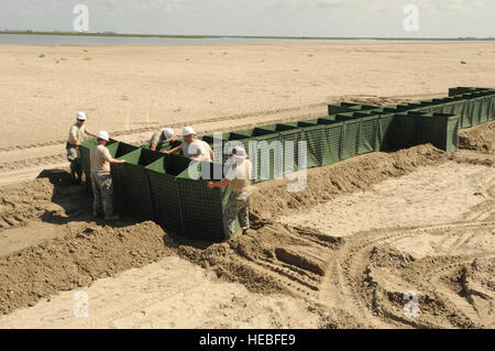 Soldiers of the Louisiana National Guard's 527th and 769th Engineer Battalions put together a wall of sand-filled Hesco Concertainer units in Port Fourchon, La., to help keep oil-tainted water from reaching Bay Champagne, May 21. Stock Photo