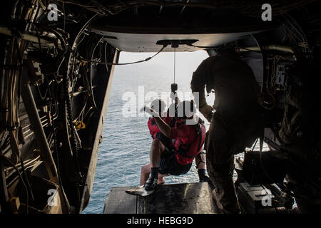 Pararescumen from the 82nd Expeditionary Rescue Squadron re-enter the aircraft after being recovered from the water while conducting hoist rescue operations as part of their requirement for upgrade training from a CV-22 Osprey flown by the 20th Expeditionary Special Operations Squadron over the Gulf of Aden after taking off from Camp Lemonnier, Djibouti, July 1, 2015. The 82nd ERQS and the 20th ESOS are deployed in support of humanitarian aid and contingency operations in the Combined Joint Task Force Horn of Africa area of responsibility. (U.S. Air Force Photo by Staff Sgt. Gregory Brook/Rele Stock Photo