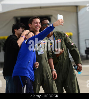 Capt. Craig Black and 1st Lt. Andre Hebert, 96st Airborne Air Control Squadron,  Kadena Air Base, Japan, pose for selfies with local Korean boys at the 2015 Seoul International Aerospace and Defense Exhibition held at Seoul Airport, Republic of Korea, Oct. 24, 2015. The Seoul ADEX gives American service members a chance to showcase their outstanding aircraft and equipment to the Korean public.  (U.S. Air Force photo/Staff Sgt. Amber Grimm) Stock Photo