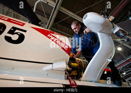 U.S. Coast Guard Petty Officer 3rd Class Jerry Lawrence, aviation maintenance technician, connects a cable to a test sensor while preparing a HH-60J Jayhawk helicopter for a rotor balance test, June 26, 2012, at Coast Guard Air Station Kodiak, Alaska. (Department of Defense photo by U.S. Air Force Tech. Sgt. Michael R. Holzworth/Released) Stock Photo