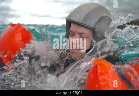 Yokota Air Base, Japan, US Air Force (USAF) Major (MAJ) Don Brien, a C-130 Hercules cargo aircraft instructor pilot with the 374th Operation Support Squadron (OSS), attempts to disconnect his canopy during parachute drag training a swimming pool. Stock Photo