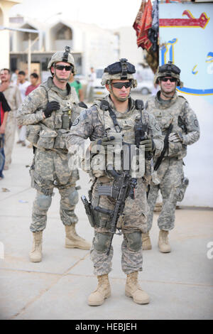 U.S. Army 1st Lt. Patrick Kerins (front), from Lambertville, N.J., Spc. Christopher Stark (back left), from Council Grove, Kan., and 1st Lt. John Hubbard (back right), from Buffalo N.Y., with Bravo Company, 35th Infantry Regiment, 2nd Battalion, 3rd Brigade, 25th Infantry Division, assigned to Patrol Base Woodcock, stand in a local street market during a joint patrol with Iraqi Police officers in Mujamma, Iraq, July 11. Stock Photo