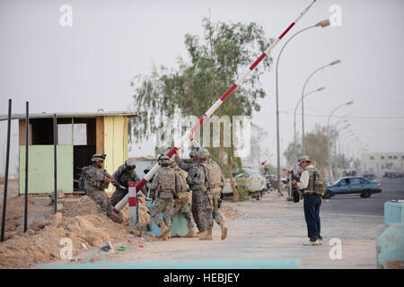 U.S. Soldiers from Bravo Company, 35th Infantry Regiment, 2nd Battalion, 3rd Brigade, 25th Infantry Division, assigned to Patrol Base Woodcock, repair a broken gate at a checkpoint near the base in Mujamma, Iraq, July 11. Stock Photo