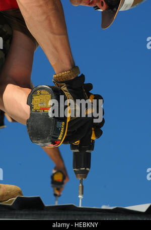 GUANTANAMO BAY, Cuba – Two Seabees drill screws into the new roof of the Chief Petty Officer’s Club, The Goat Locker, Dec. 29. The Seabees are attached to Naval Mobile Construction Battalion 28, Shreveport, La., which is deployed to Guantanamo Bay in support of general engineering, construction and project management for Naval Station Guantanamo Bay. JTF Guantanamo provides safe, humane, legal and transparent care and custody of detainees, including those convicted by military commission and those ordered released by a court. The JTF conducts intelligence collection, analysis and dissemination Stock Photo