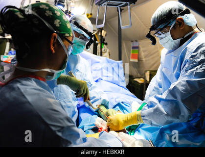 Members of the 541st Forward Surgical Team perform surgery on a five-year-old Afghan boy's broken leg at Camp Pannonia, Afghanistan, Dec. 19. The 541st FST has ten members in Pol-e Khumri and provide life saving surgical and resuscitative care to the region. Stock Photo