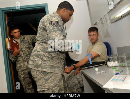 Oregon Air National Guard Staff Sgt. Clifton Matthews, 142nd Fighter Wing Medical Group, prepares to take blood samples from Staff Sgt. Rockney Schock (right) and Senior Airmen Benjamin Courtney (left), 142nd Fighter Wing Security Forces Squadron, as part of the in-processing procedures at the Portland Air National Guard Base, Ore., Aug. 9, 2013. (Air National Guard photo by Tech. Sgt. John Hughel, 142nd Fighter Wing Public Affairs/released) Stock Photo