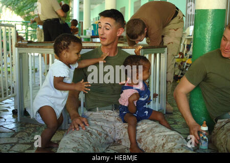 DJIBOUTI – During a visit to the Djibouti baby orphanage, Marine 1st Lt. Tim J. Lockhart spends time with children after assisting French nuns feed more than 60 babies and toddlers cared for at the facility. Lockhart, an Arlington, Va., native, is the Bravo Battery platoon commander for the 3rd Low Altitude Air Defense Battalion. The battalion is deployed from Camp Pendleton, Calif., to Camp Lemonier, Djibouti, where the Marine battalion provides security to those who are supporting the Combined Joint Task Force-Horn of Africa mission to prevent conflict, promote regional stability, protect co Stock Photo