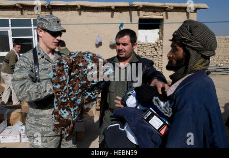 Lt. Col. (Dr.) Thomas Knolmayer helps distribute blankets at a humanitarian assistance visit. The clothes, shoes, coats and blankets brought to the refugee camp were donated to Operation Care by American citizens. stance visit. The items distribute were donated to Operation Care by American citizens. Donations increased after a 5-year-old boy was treated at the Craig Theater Hospital here who had no shoes. The doctor caring for him, Col. Knolmayer, called home and asked his wife to send a pair of his son's shoes for the child, sparring a rash of shoe donations. The colonel is a general surgeon Stock Photo