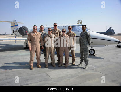Airmen assigned to the 379th Air Expeditionary Group C-21 Firebass unit pose for a photo at the 379th Air Expeditionary Wing in Southwest Asia, Nov. 5, 2013. The C-21's primary mission here is distinguished visitor transport throughout the U.S. Air Forces Central Command area of responsibility. The members are deployed from Joint Base Andrews, Md., and Scott Air Force Base, Ill. (U.S. Air Force photo/Senior Airman Bahja J. Jones) Stock Photo