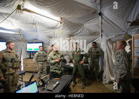 U.S. Air Force Col. Patrick McAtee, the Virginia Air National Guard’s 192nd Operations Group commander out of Joint Base Langley-Eustis, Va., serving on temporary duty as the deployed forces commander for RED FLAG-Alaska (RF-A) 16-2, center, is briefed on operations by U.S. Army commanders from the 1st Battalion, 24th Infantry Regiment, Fort Wainwright, Alaska, June 8, 2016, while visiting the Joint Pacific Alaska Range Complex (JPARC) during RF-A 16-2. The JPARC provides a realistic training environment and allows commanders to train for full spectrum engagements, ranging from individual kill Stock Photo