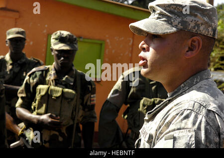 Soldiers with the Uganda people's defence force assemble and receive instructions from Army Sgt. Daniel LeGeer at the starting point of a 5.4 mile run that is part of a squad competition at Forward Operating Location Kasenyi, Uganda, April 3, 2008. The soldiers are training with members of the 1st Battalion, 3rd U.S. Infantry Regiment (The Old Guard), deployed from Ft. Myer, Va. The timed squad competition requires the UPDF soldiers to demonstration their ability along a 5.4 mile course providing medical care in the field, plotting five terrain features on a map, calling in a 'Nine Line' repor Stock Photo