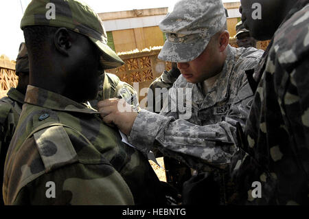 Soldiers with the Uganda people's defence force assemble and receive instructions from Army Sgt. Daniel LeGeer at the starting point of a 5.4 mile run that is part of a squad competition at Forward Operating Location Kasenyi, Uganda, April 3, 2008. The soldiers are training with members of the 1st Battalion, 3rd U.S. Infantry Regiment (The Old Guard), deployed from Ft. Myer, Va. The timed squad competition requires the UPDF soldiers to demonstration their ability along a 5.4 mile course providing medical care in the field, plotting five terrain features on a map, calling in a 'Nine Line' repor Stock Photo