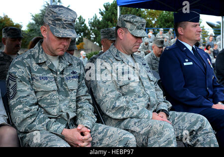 From left to right, U.S. Air Force Chief Master Sgt. Brian Gates, 52nd Fighter Wing command chief, U.S. Air Force Col. Lars Hubert, 52nd FW vice commander, and U.S. Air Force Col. Pete Bilodeau, 52nd FW commander, take a moment of silence during a 9/11 ceremony at the Spangdahlem Air Park Memorial Sept. 11, 2014, at Spangdahlem Air Base, Germany. The ceremony started at 2:46 p.m., or 8:46 a.m. EST, the exact time the first plane struck the North Tower in New York City. (U.S. Air Force photo by Airman 1st Class Luke J. Kitterman/Released) Stock Photo