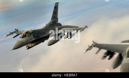 A pair of F-16 Fighting Falcons from Homestead Air Reserve Base, Fla., break off after receiving fuel from a KC-135 Stratotanker from the Transit Center at Manas, Kyrgyzstan, over the skies of Afghanistan Dec. 14, 2013. F-16s with two external fuel tanks can carry approximately 1,800 gallons of fuel and the KC-135 is capable of delivering about 1,000 gallons of fuel per minute. (U.S. Air Force photo/Staff Sgt. Travis Edwards) Stock Photo