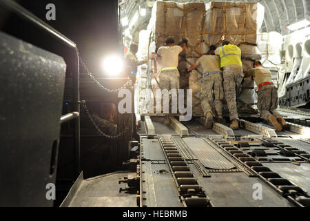 U.S. Air Force Senior Airman Tyrone McClellan, lower left, assigned to the 386th Expeditionary Logistics Readiness Squadron, waits as fellow Airmen push a pallet of nonlethal aid bound for Syria's opposition coalition into an Air Force C-17 Globemaster III aircraft at an undisclosed base in Southwest Asia May 21, 2013. U.S. forces provided humanitarian aid to refugees of the Syrian civil war. (U.S. Air Force photo by Senior Master Sgt. George Thompson/Released) Stock Photo