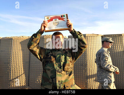 An Afghan national army soldier proudly displays his certificate of completion during the Task Force Legion Academy graduation ceremony at Forward Operating Base Ramrod, Afghanistan, Dec. 26, 2009. Members of the Afghan national security forces attended a two-week training course learning various tactics, techniques and procedures to help them with their day-to-day operations. (U.S. Air Force photo by Staff Sgt. Dayton Mitchell/Released) Stock Photo