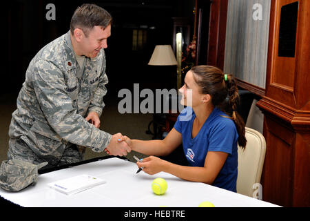 Maj. Daniel Thompson, 628th Air Base Wing Chaplain, gives a coin to professional tennis player Lauren Davis April 1, 2014, during a base tour of Joint Base Charleston, S.C. The tour included signing autographs at the Charleston Club followed by a C-17A Globemaster III static tour. (U.S. Air Force photo/Staff Sgt. Renae Pittman) Stock Photo