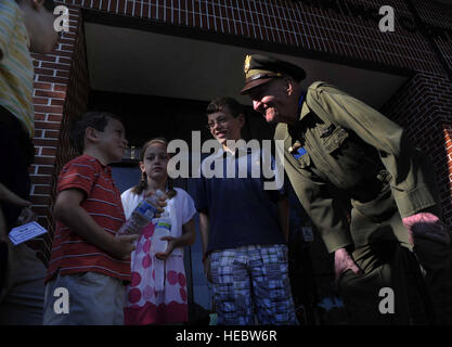 Retired Col. Gail Halvorsen, the famed 'Candy Bomber', speaks with children moments after the C-17 Aircrew Training Center was dedicated in honor of him, as one of the finest mobility legends. Halvorsen was a command pilot in the United States Air Force. He is best known for piloting C-47s and C-54s during the Berlin Airlift from 1948-1949. Halvorsen dropped candy attached to parachutes to children below. His main goal was to raise the morale of the children during the time of uncertainty. Stock Photo