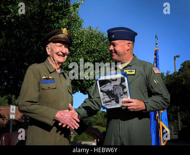 Retired Col. Gail Halvorsen, the famed 'Candy Bomber,' is handed a certificate by Col. Erik Hansen, 437th Airlift Wing commander, moments after the C-17 Aircrew Training Center was dedicated in honor of him, as one of the finest mobility legends. Halvorsen was a command pilot in the United States Air Force. He is best known for piloting C-47s and C-54s during the Berlin Airlift from 1948-1949. Halvorsen dropped candy attached to parachutes to children below. His main goal was to raise the morale of the children during the time of uncertainty. Stock Photo