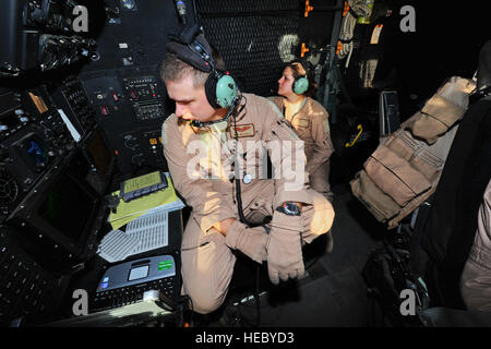 U.S. Air Force Capt. Jeff Mitchell, navigator, (left) and Airman 1st Class Jamie Dalton, airborne mission systems specialist from the 81st Expeditionary Rescue Squadron, monitor their stations aboard an HC-130P Combat King on a training mission July 30, 2012, over the Grand Bara Desert, Djibouti. The 82nd ERQS and pararescuemen from the 81st ERQS were conducting training exercises in support of Combined Joint Task Force - Horn of Africa. Stock Photo
