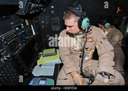 U.S. Air Force Capt. Jeff Mitchell, navigator, (left) and Airman 1st Class Jamie Dalton, airborne mission systems specialist from the 81st Expeditionary Rescue Squadron monitor their stations aboard an HC-130P Combat King on a training mission July 30, 2012, over the Grand Bara desert, Djibouti. The 82nd ERQS and pararescuemen from the 81st ERQS were conducting training exercises in support of Combined Joint Task Force - Horn of Africa. Stock Photo