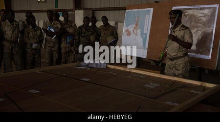 A Djiboutian Armed Forces (FAD) officer briefs his troops before a mission as part of a culmination exercise outside of Djibouti City, Djibouti, May 11, 2015. U.S. Army Soldiers from the 47th Transportation Company, 142nd Combat Sustainment Support Battalion, 1st Armored Division Sustainment Brigade; the 123rd Brigade Support Battalion, 3rd Brigade, 1st Armored Division; and U.S. Navy Seabees from Naval Mobile Construction Battalion 14 conducted counter-improvised explosive device, medical, and heavy equipment training. The training exercises are a culmination event for the FAD, happening for  Stock Photo