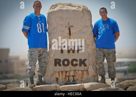 In anticipation of the upcoming NFL regular season kickoff, airmen deployed overseas at the 386th Air Expeditionary Wing pose for a photo at the 386th AEW's 'Rock' monument, proudly wearing their Detroit Lions gear, Sunday, Aug. 25, 2013. Pictured are: (left to right) Tech. Sgt. David Motycka, a Lawton, Mich., native and Airman 1st Class Aaron Goodrich, a Saginaw, Mich., are members of the Battle Creek-based 110th Airlift Wing of the Michigan Air National Guard. (U.S. Air Force Photo by Master Sgt. Christopher Campbell) Stock Photo