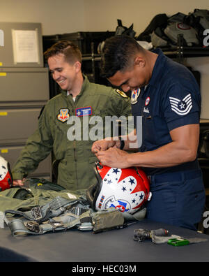 U.S. Air Force Tech. Sgt. Paul Rosales, aircrew flight equipment specialist with the U.S. Air Force Air Demonstration Squadron, right, shares a laugh with Brendan Lyons, Tucson community hometown hero, as he adjusts the fit of a helmet at Davis-Monthan Air Force Base, Ariz., March 11, 2016.  Lyons was nominated as a hometown hero to fly with the Thunderbirds because of his commitment to safety and his passion to make Tucson a safer community for cyclists and motorists. (U.S. Air Force photo by Senior Airman Chris Massey/Released) Stock Photo