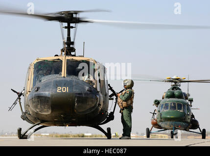 An Iraqi UH-1H Iroquois 'Huey' helicopter and an Iraqi Mi-17 Hip helicopter prepare to transport a wounded Iraqi servicemember from Joint Base Balad, Iraq, to Forward Operating Base Gabe in Baqubah, Iraq, Nov. 21. The servicemember arrived at the Air Force Theater Hospital  at Joint Base Balad Nov. 16 with a gunshot wound to his leg. The Iraqi air force is developing its aeromedical evacuation capabilities to take on a greater role in transporting its patients. (U.S. Air Force photo/Airman 1st Class Jason Epley) Stock Photo