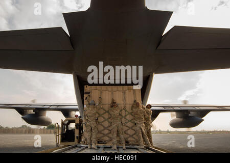 Tech. Sgt. Jonnedi Paule, Spc. Alexander Anderson, Staff Sgt. Daniel Hall and Staff Sgt. Andrey Benchea, 19th Movement Control Team aerial porters, prep a 'tricon' shipping container for a 774th Expeditionary Airlift Squadron C-130 Hercules cargo plane at Forward Operating Base Salerno, Khost Province, Afghanistan, Sept. 22, 2013. The 19th MCT, a small squadron of Air Force surface movement controllers and aerial porters, have the herculean task of overseeing the vast majority of retrograde operations at FOB Salerno. Paule, a St. Paul, Minn. native, Hall, a Smith Valley, Nev. native and Benche Stock Photo