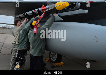 U.S. Airmen with a weapons load crew with the 48th Air Expeditionary Group mount an AIM-9X Sidewinder missile onto an F-15C Eagle aircraft assigned to the 493rd Expeditionary Fighter Squadron March 19, 2014, as part of Baltic Air Policing in ?iauliai, Lithuania. The U.S. Air Force assumed command of the NATO Baltic Air Policing mission for a four-month rotation from January to May of 2014. (U.S. Air Force photo by Airman 1st Class Dana J. Butler/Released) Stock Photo