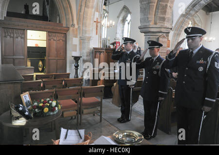 U.S. Airmen with the 422nd Air Base Group Honor Guard salute during a memorial service at the Church of St. Mary Magdalene in Helmdon, England, Nov. 2, 2013. The ceremony honored 10 Airmen assigned to the 327th Bombardment Squadron who were killed when their B-17 Flying Fortress aircraft, Sharon Belle, crashed at Astwell Castle Farms during a bombing mission Nov. 30, 1943. (U.S. Air Force photo by Staff Sgt. Brian Stives/Released) Stock Photo