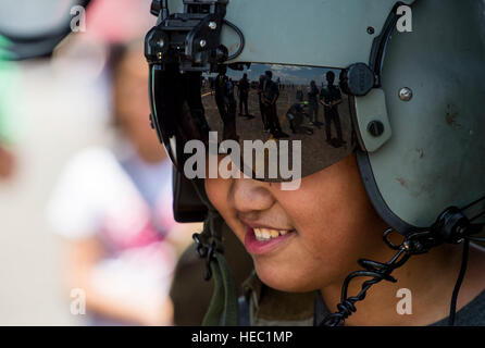 A Philippine boy tries on a pilot helmet during a static display at Clark Air Base, Philippines, April 9, 2016. U.S. military and Armed Forces of the Philippines hosted the event displaying various aircraft from all U.S. services and the Philippine Air Force. This year marks the 32nd iteration of Balikatan where U.S. service members continue to work “shoulder-to-shoulder” with members of the Armed Forces of the Philippines to increase combined readiness to crises and conflict across the Indo-Asia-Pacific region. (U.S. Air Force photo by Tech. Sgt. Araceli Alarcon/Released) Stock Photo