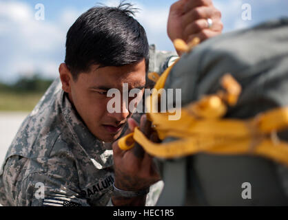 U.S. Army Sgt. David H. Pa'aluhi, a paratrooper with the 1st Battalion, 503rd Infantry Regiment, 173rd Airborne Brigade Combat Team, rigs a Bulgarian soldier's parachute during Steadfast Javelin II at Ramstein Air Base, Germany, Sept. 2, 2014. Steadfast Javelin II is a NATO-led exercise designed to prepare U.S., NATO and international partner forces for unified land operations. (U.S. Air Force photo by Senior Airman Damon Kasberg/Released) Stock Photo