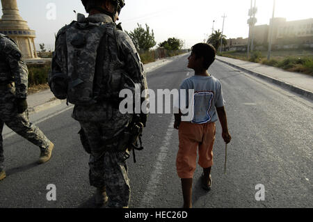 U.S. Army Cpt. Vincent Cesaro, a native of Chicago, Ill., befriends an Iraqi boy during a visit to the Iraqi family village in Baghdad, Iraq on Sep. 1, 2008. The U.S. Soldiers are part of Headquarters Headquarters Battery, 1st Battalion, 320th Field Artillery Regiment, 2nd Brigade Combat Team, 101st Airborne Division. Stock Photo