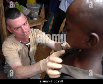 U.S. Army Sgt. 1st Class Robert Gutman, a field medic deployed with Operation ONWARD LIBERTY from Ypsilanti, Mich., performs a physical examination on a child during a medical outreach visit to Gondor Town, Liberia, July 2, 2013. The AFL led a 14-person medical outreach team including doctors, nurses and a support staff to three villages deep in the jungles of Grand Cape Mount County, Liberia, from July 1 to July 4, 2013. The medical outreach mission was a first for the AFL which was restructured in 2005 following 15 years of civil war. OOL advisors have been mentoring the AFL since 2010.  OOL Stock Photo