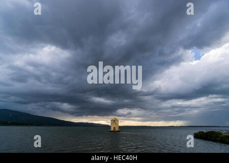 The spanish windmill emerges from the lagoon, dark sky in the distance Stock Photo