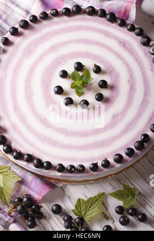 Beautiful striped black currant cheesecake close-up on the table. vertical Stock Photo