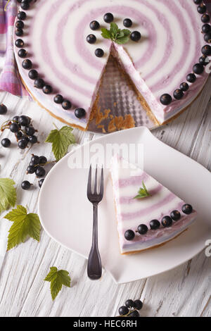 Beautiful sliced cheese cake with currants close-up on the table. vertical top view Stock Photo